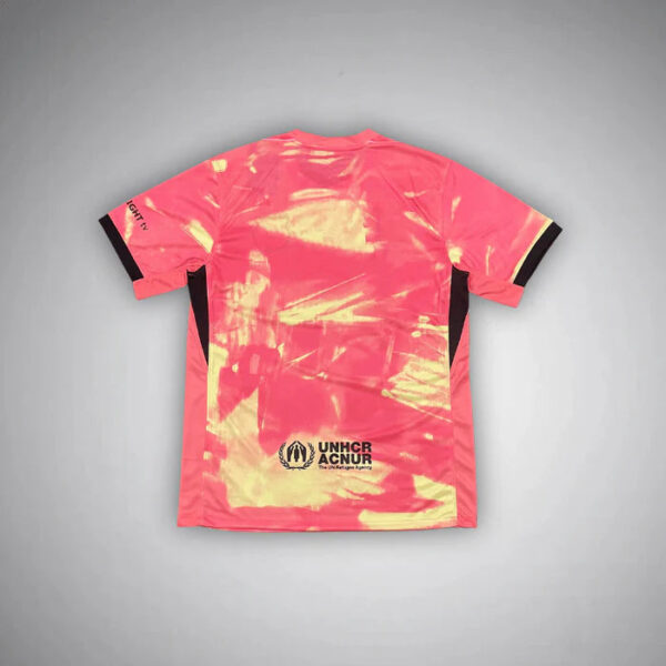 Pink athletic jersey with black-trimmed sleeves, featuring a pink-to-cream tie-dye pattern and the UNHCR ACNUR logo near the bottom back.