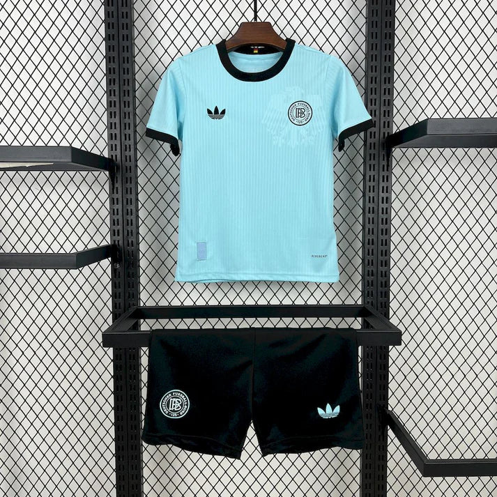 2025050114360345 | UAE SPORT STORE Light blue soccer jersey with black trim on display above black shorts on a metal rack promotes athletic wear.