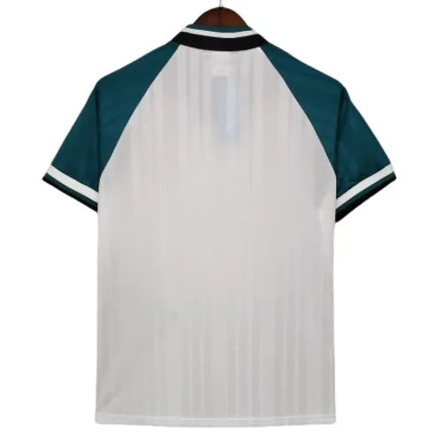 Back view of a white short-sleeve sports jersey with teal sleeves and striped collar, hanging on a wooden hanger