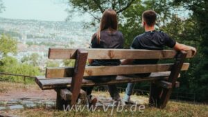 2048x1152_04_00000_fw_1152x648_b35583d4-5464-4214-84fe-158f9ea92dc3 | UAE SPORT STORE Two people sit on a wooden bench, seen from behind, overlooking a town from a hillside park.
