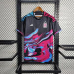 Black Adidas Argentina soccer jersey with a bold pink, blue, and white swirl design, hanging on a wooden hanger against a metal grid display.