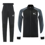 Black and gray Nike tracksuit: zip-up jacket with white swoosh and AIR logo, matching black jogger pants with Nike emblem on thigh.