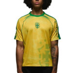 Person wearing a yellow Brazil soccer jersey with green trim and crest on the chest, facing forward.