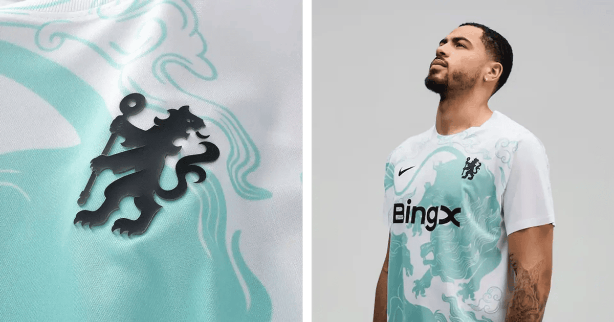 Close-up of turquoise fabric with a black Chelsea lion crest and flowing swirl patterns nearby.