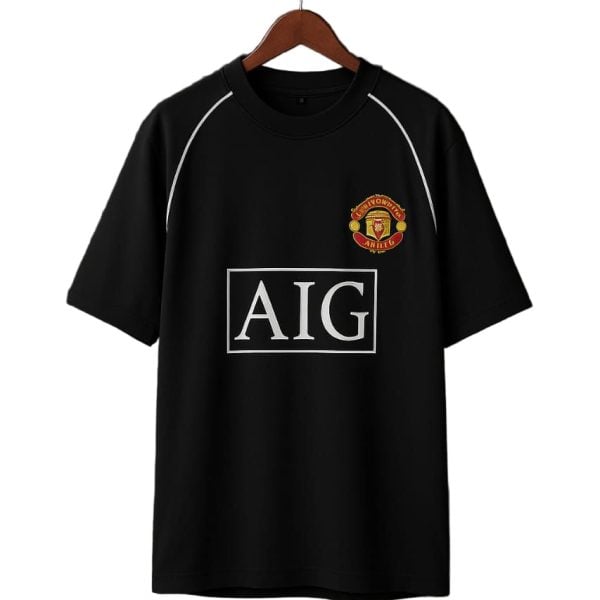 Black T-shirt on a hanger with Manchester United crest and AIG sponsor logo on the front.