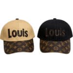 Two Louis Vuitton–style baseball caps: beige front with black 'LOUIS' text and monogram-brim, and a black version with brown embroidered letters and patterned brim patterns.