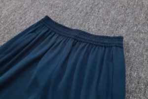 Blue elastic-waist skirt laid flat on a gray carpet.