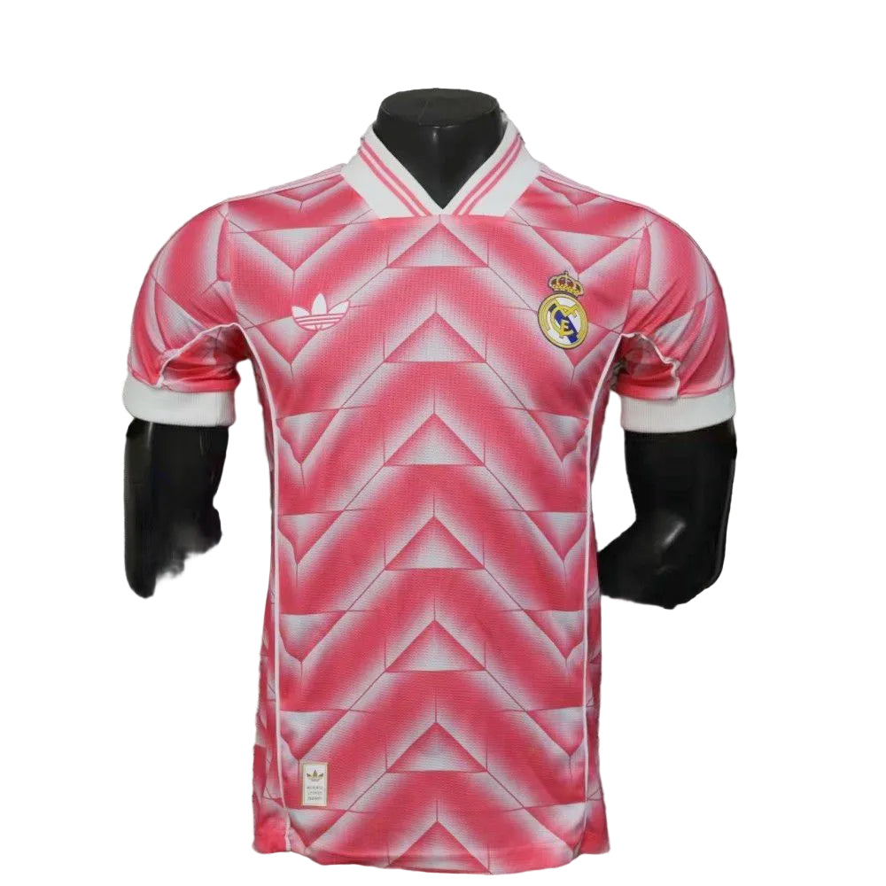 2300845e-d794-4a78-874f-76e0e460a262 | UAE SPORT STORE Pink Real Madrid soccer jersey with geometric pattern on a mannequin, white collar and Real Madrid crest on the chest.