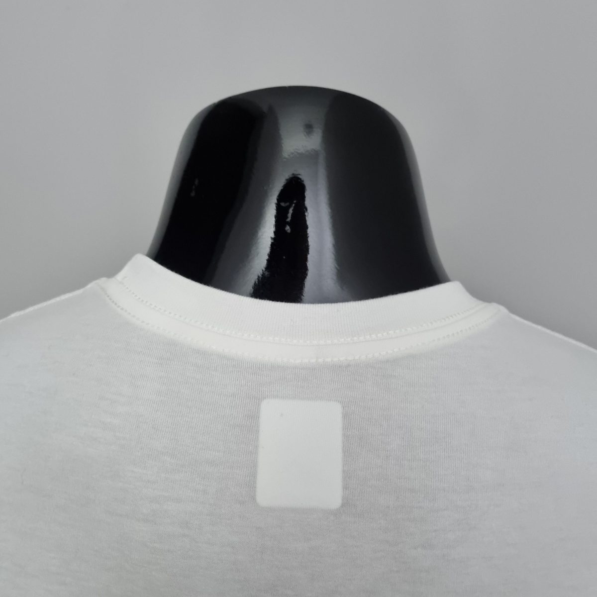 Close-up of a glossy black curved object emerging from white fabric.