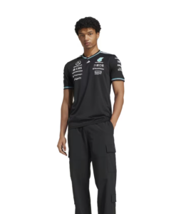 Young man wearing a black motorsport jersey and cargo pants, standing with hands at his sides against a white background.