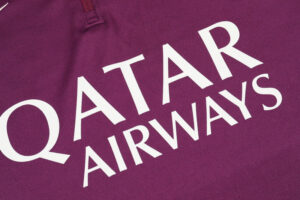 Qatar Airways logo in white on maroon fabric, shown diagonally across the image.