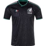 Black Mexico national soccer jersey with teal trim and geometric pattern; crest on left chest and Adidas logo on right.