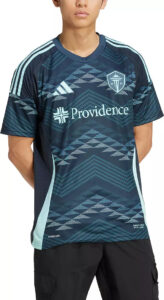 Male model wearing a dark blue Providence soccer jersey with light blue chevron pattern and sponsor logo on the chest.
