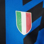 Close-up of a soccer jersey badge featuring the Italian flag colors (green, white, red) and the number 20 on a shield.