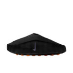 Black soccer cleat with orange studs and a small purple Nike swoosh, viewed from the side.