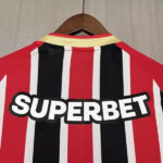 Back of a red, black, and white striped sports jersey with a bold 'SUPERBET' sponsor logo across the back.