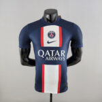 Paris Saint‑Germain football jersey on a mannequin, navy with white and red vertical panels and Qatar Airways sponsor logo.