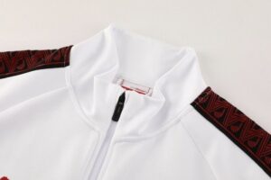 White zip-up jacket with a high collar and red/black patterned shoulder stripes visible on the sleeves