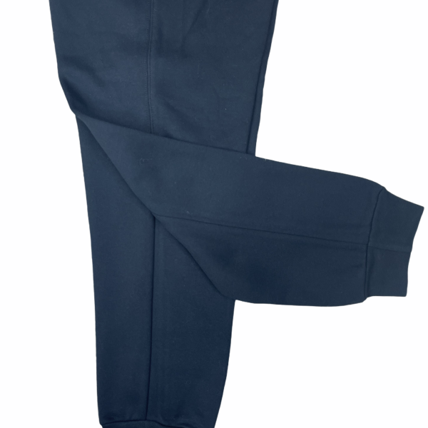 Close-up of a navy blue pant leg with a visible seam and cuff at the bottom, laid flat.