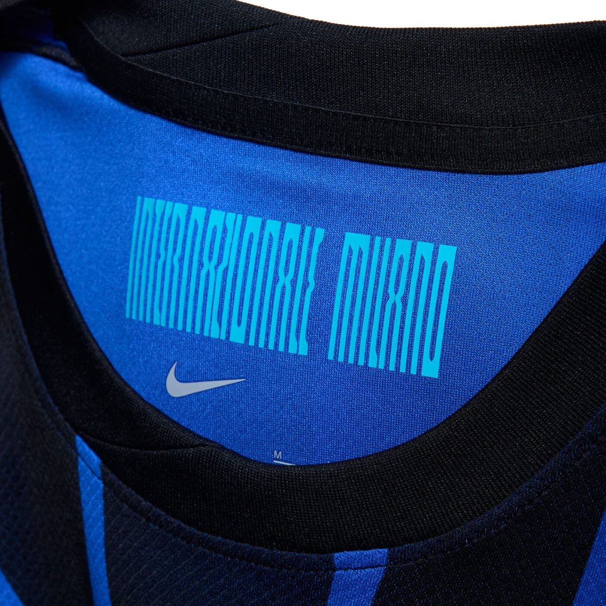 Close-up of a blue and black sports jersey neckline with barcode-like text and the white Nike swoosh.