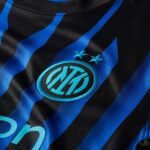 Close-up of an Inter Milan jersey showing blue-and-black stripes and the club crest with two stars above it.