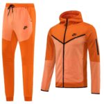 Orange Nike tracksuit set with zip-up jacket and jogger pants, bright athletic wear with black zipper and swoosh logo.