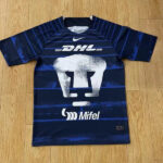 Navy blue soccer jersey with DHL and Mifel logos and a large white elephant graphic on the front, laid flat on a wooden floor.