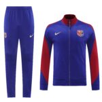 Royal blue FC Barcelona tracksuit jacket with red sleeves and crest, paired with matching blue pants and Nike swoosh logo on the thigh/hip area.