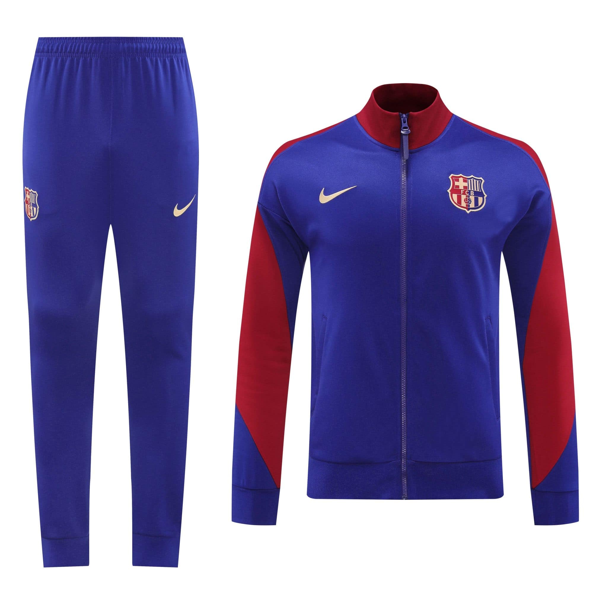 2706c235 | UAE SPORT STORE Royal blue FC Barcelona tracksuit jacket with red sleeves and crest, paired with matching blue pants and Nike swoosh logo on the thigh/hip area.