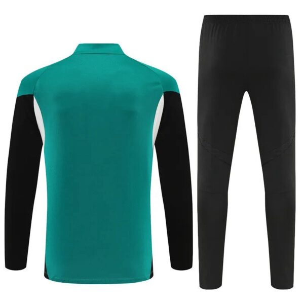 Back view of a teal long-sleeve athletic jersey with black sleeves and white side panels, paired with black athletic pants.