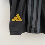 Close-up of a black fabric with three golden diagonal chevron stripes as an insignia on a garment.