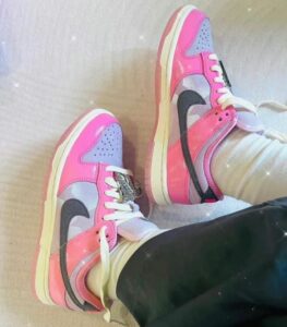 Pair of pink and lavender sneakers with white laces on a person’s feet