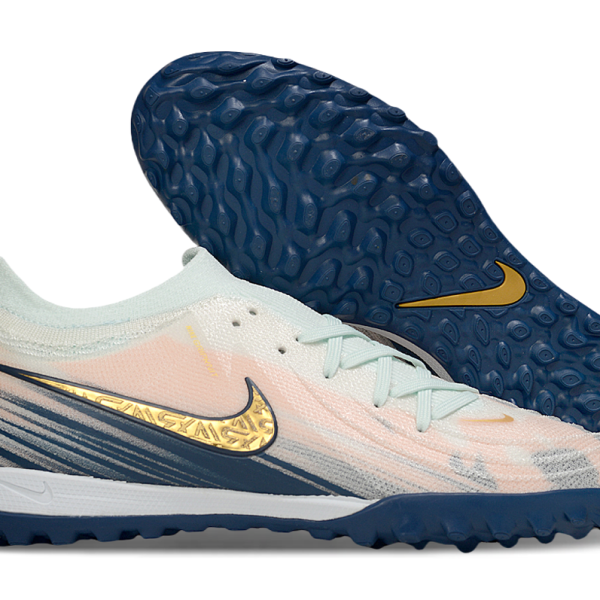Nike turf soccer shoe with pale pink upper, mint laces, and dark blue outsole featuring a gold swoosh.