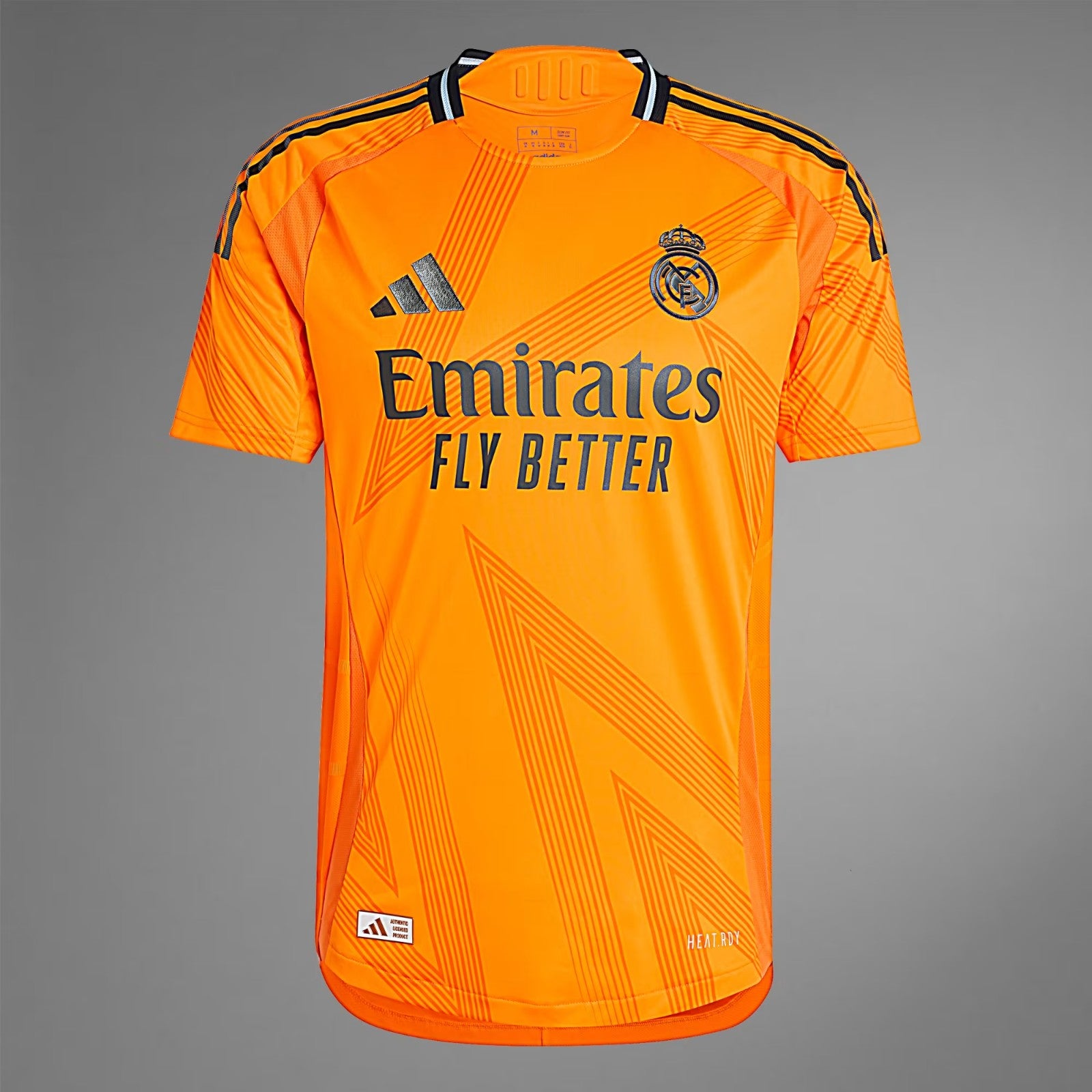 28lEgSJ5OZAIDsI | UAE SPORT STORE Orange Real Madrid jersey with Emirates Fly Better sponsor and Adidas logo on the chest, featuring club crest on the right side.
