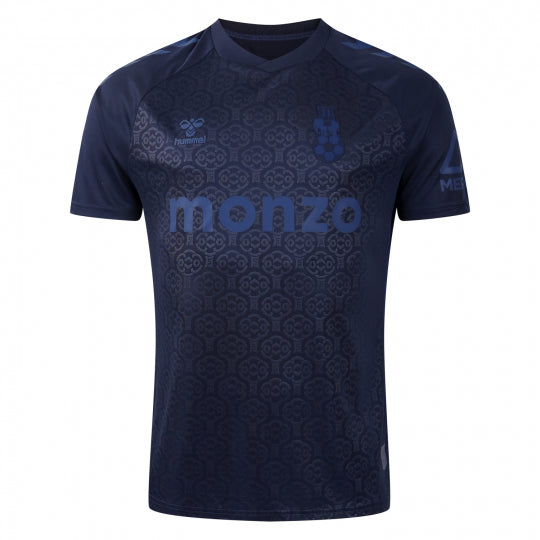 Navy blue soccer jersey with a subtle geometric pattern, Monzo sponsor across the chest, and the Hummel logo on the left chest.