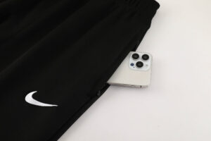 29a30c52 | UAE SPORT STORE Black Nike joggers with a white swoosh; a silver iPhone peeks out of the side pocket.