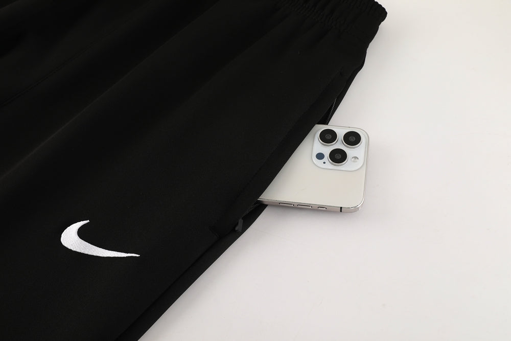 29a30c52 | UAE SPORT STORE Black Nike joggers with a white swoosh; a silver iPhone peeks out of the side pocket.