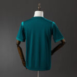 Back view of a teal short-sleeve athletic jersey on a dress form mannequin