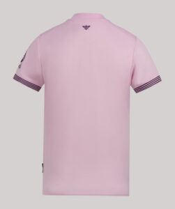 Back view of a light pink polo shirt with navy striped sleeve cuffs and a small dark bee emblem near the neck area.