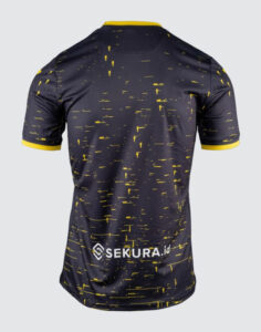 Back view of a dark navy athletic jersey with yellow speckle pattern, yellow sleeve cuffs, and a SEKURA.id logo near the lower back.