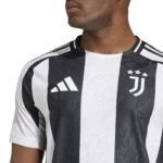 Close-up of a person wearing a black-and-white Juventus jersey with the Adidas logo and the club crest with stars on the chest.