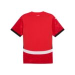 Back view of a red athletic jersey with black sleeve cuffs and a white horizontal band near the lower back.