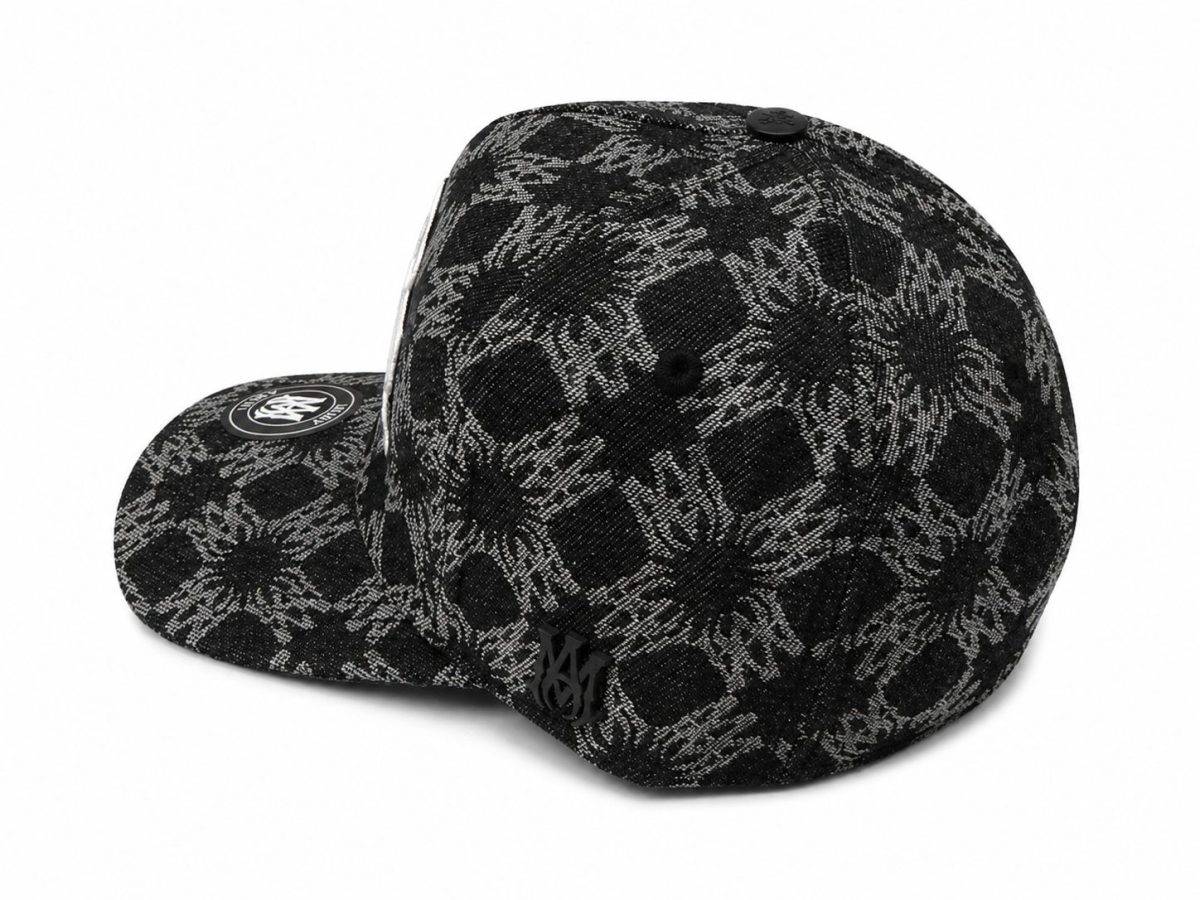 Black baseball cap with a black-and-gray floral pattern and a round logo patch on the brim, shown from a side angle.