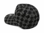 Black monogram cap featuring skull and floral patterns, stylish and trendy headwear.