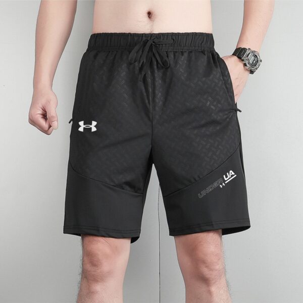Man wearing black athletic shorts with a drawstring waist; visible Under Armour logo on left thigh and patterned fabric texture.