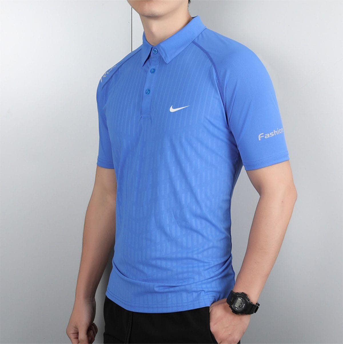 Person wearing a bright blue polo shirt with a white Nike logo, standing against a gray background.