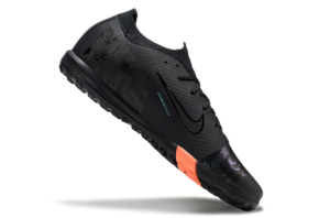 2a7bb6e5 | UAE SPORT STORE Black running shoe with textured upper, orange heel accent, and rugged outsole shown at an angled side view.