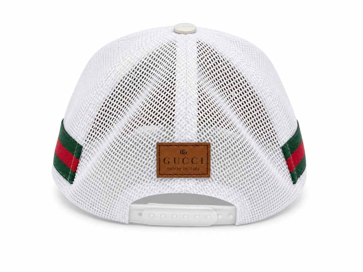 Back view of a white Gucci mesh baseball cap with a brown leather label and green-red webbing straps, adjustable snap closure at the rear.