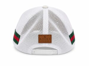 Back view of a white Gucci mesh baseball cap with a brown leather label and green-red webbing straps, adjustable snap closure at the rear.