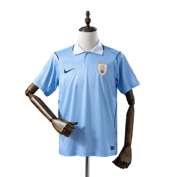 Light blue Uruguay national team soccer jersey on a mannequin, featuring a white collar, Nike swoosh, and crest with stars on the left chest